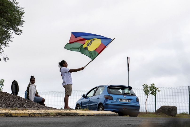 Une femme brandit un drapeau du Front de libération nationale kanak et socialiste (FLNKS) à Nouméa, en Nouvelle-Calédonie