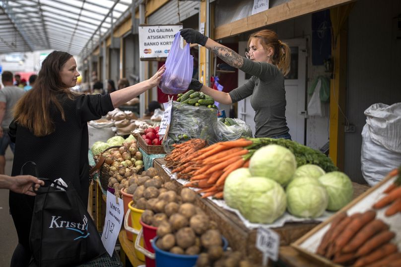 Une femme vend des légumes au bazar de Vilnius, juillet 2023