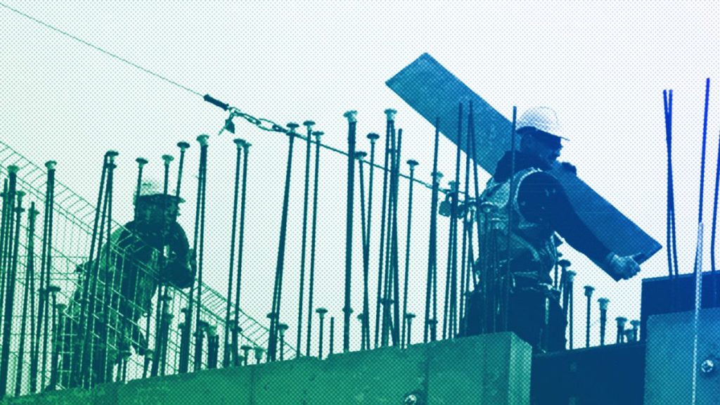 Builders are silhouetted as they work at a construction site in London, September 2018