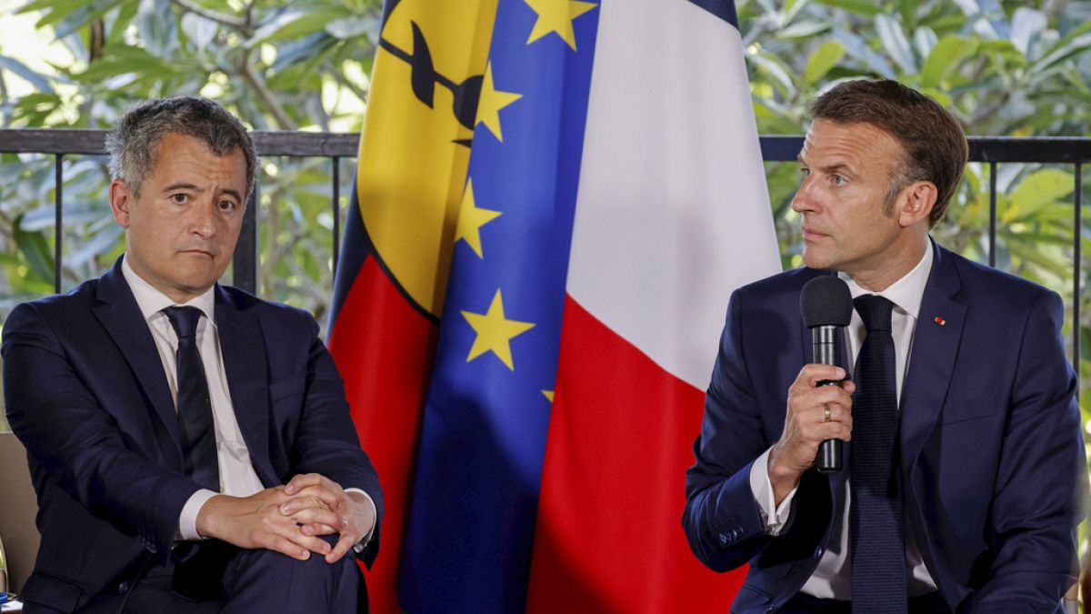 French President Emmanuel Macron sits next to France