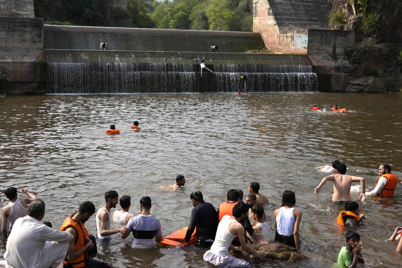 Les jeunes Pakistanais se rafraîchissent dans un ruisseau par temps de chaleur extrême. 