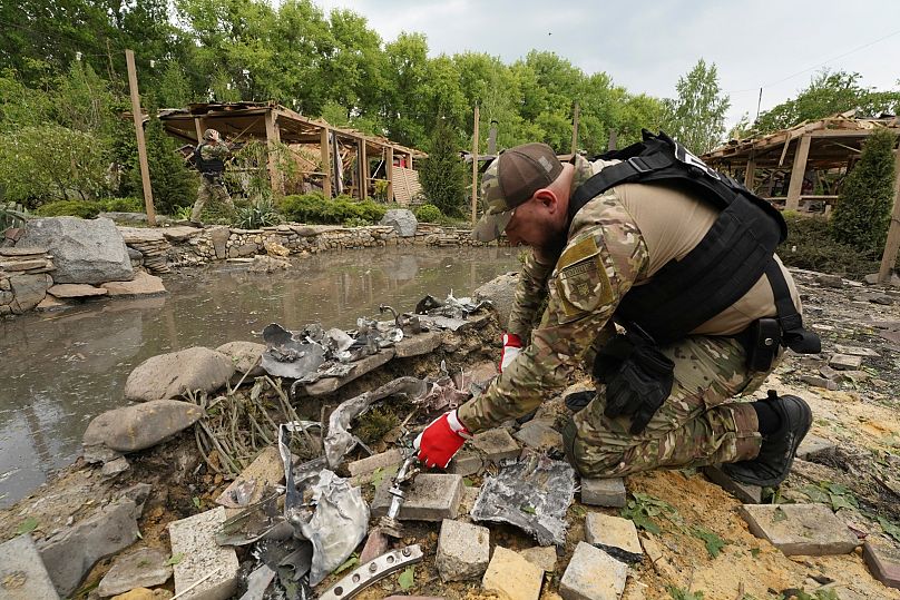 Un sapeur inspecte des fragments de missiles russes qui ont touché une zone de loisirs, tuant cinq personnes et en blessant 16 autres dans la banlieue de Kharkiv, en Ukraine, le dimanche 19 mai 2024.