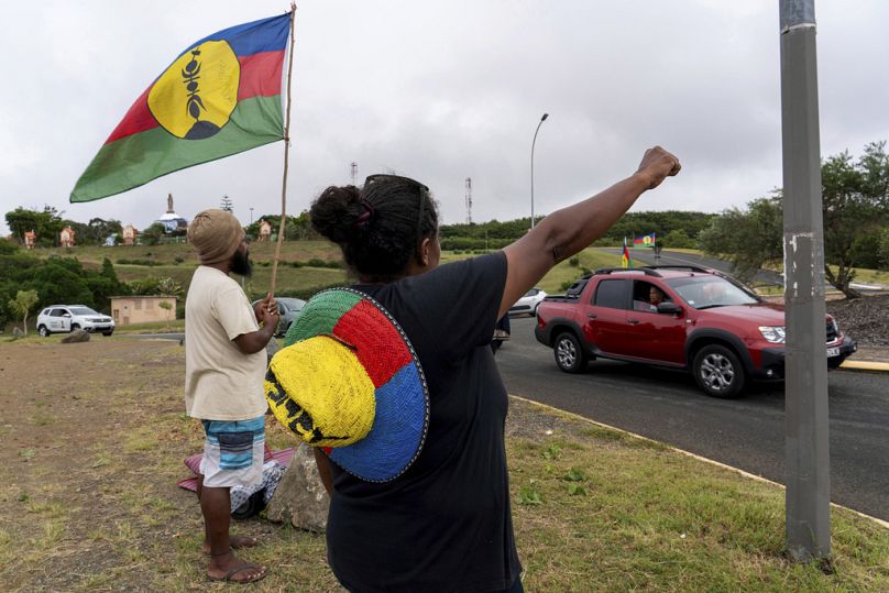 Une femme brandit un drapeau du Front de libération nationale kanak et socialiste (FLNKS) à Nouméa, en Nouvelle-Calédonie