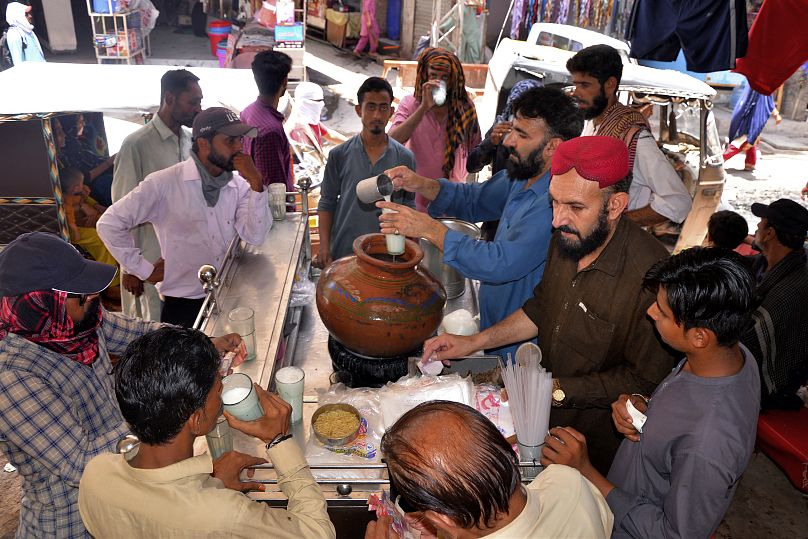 Des gens boivent de l’eau sucrée dans un stand à Hyderabad, au Pakistan.