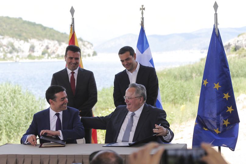 Les Premiers ministres grec et macédonien Zoran Zaev et Alexis Tsipras regardent les ministres des Affaires étrangères Nikos Kotzias et Nikola Dimitrov signer l'accord de Prespa, le 17 juin 2018.