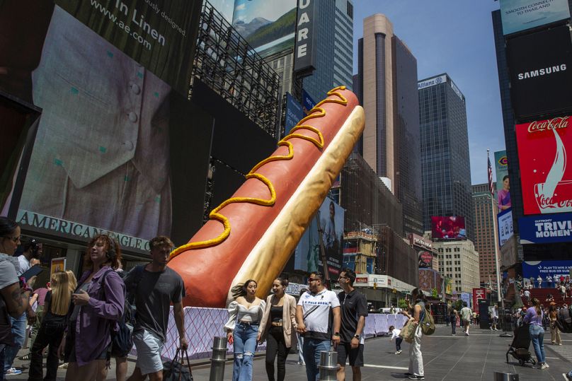 Une sculpture de 65 pieds de long intitulée Hot Dog in the City par les artistes Jen Catron et Paul Outlaw se trouve à Times Square à New York, mai 2024.