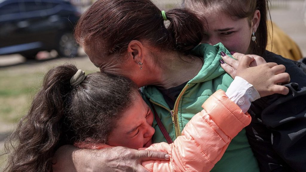 Khrystyna Pyimak, 11, hugs her mother Oksana Velychko, 42, after evacuation from Vovchansk, 12 May 2024