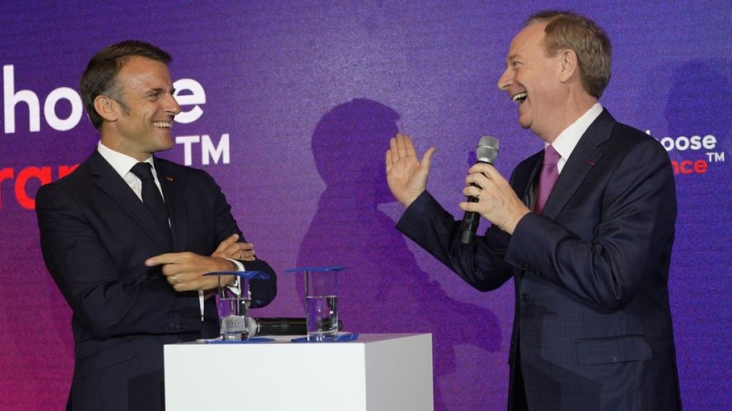 Microsoft CEO Brad Smith, right, speaks to French President Emmanuel Macron at the French Microsoft headquarters in Issy-les-Moulineaux, outside Paris. May 13, 2024.