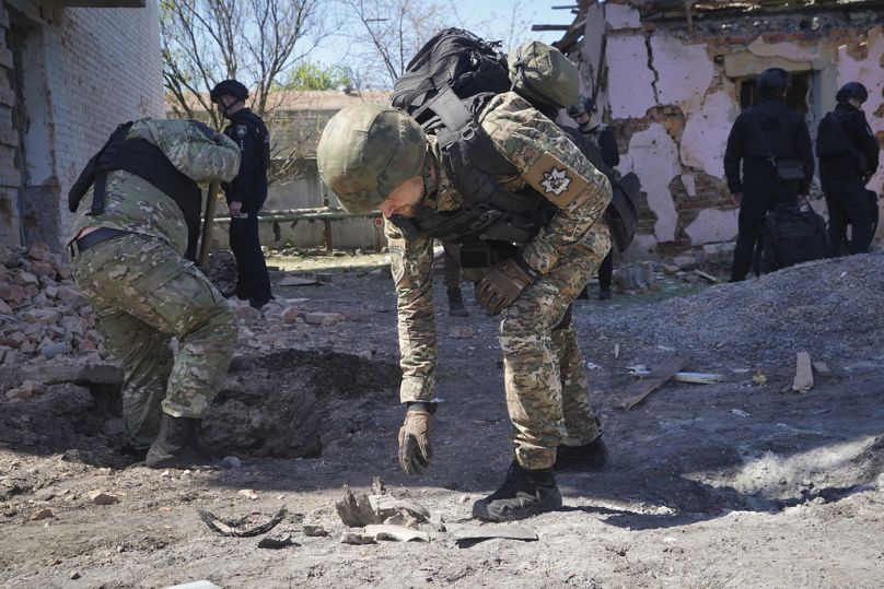 Un policier examine les fragments d'une bombe guidée après le raid aérien russe à Kharkiv, en Ukraine, le mardi 30 avril 2024.