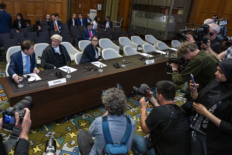 Des journalistes prennent des photos de l'équipe juridique israélienne à la Cour internationale de Justice à La Haye, le 24 mai 2024.