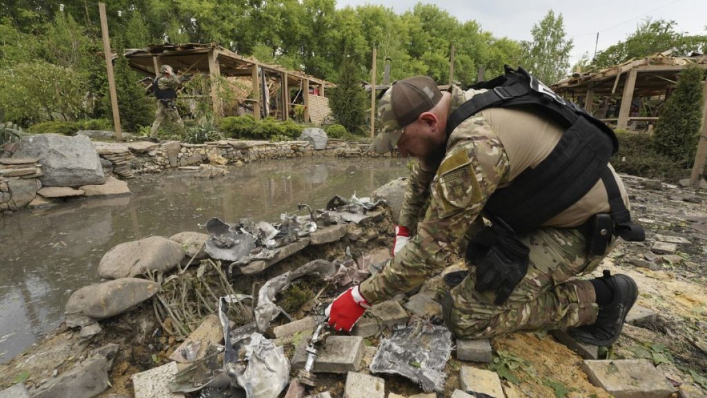 A sapper inspects fragments of Russian missiles that hit a recreation area killing five, and injuring 16, in the outskirts of Kharkiv, Ukraine, Sunday, May 19, 2024.