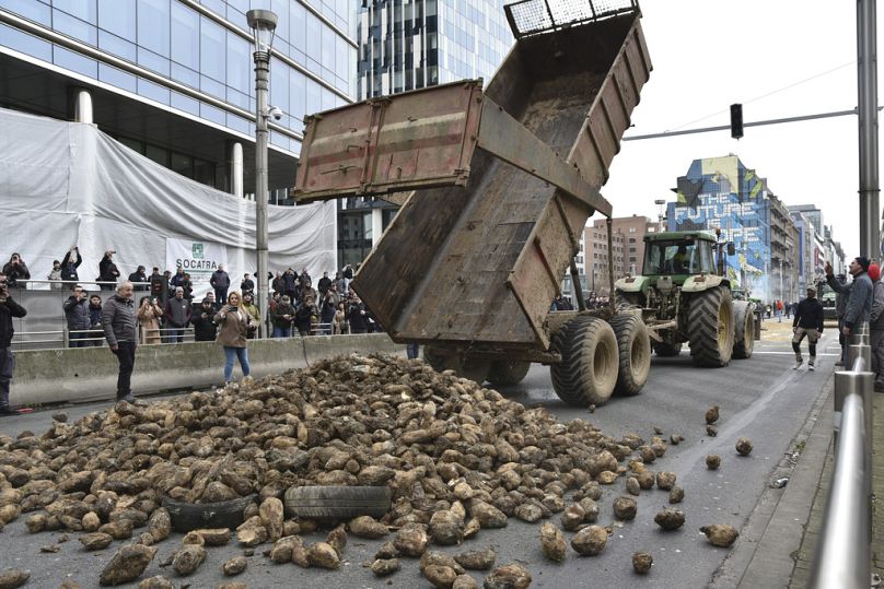 DOSSIER – Des agriculteurs protestataires déversent un chargement de produits sur un boulevard principal lors d’une manifestation devant le bâtiment du Conseil européen à Bruxelles, le 26 mars 2024.