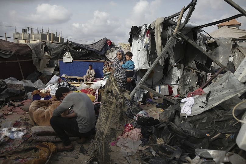 Des Palestiniens déplacés inspectent leurs tentes détruites par une frappe israélienne à l'ouest de Rafah, le 28 mai 2024.