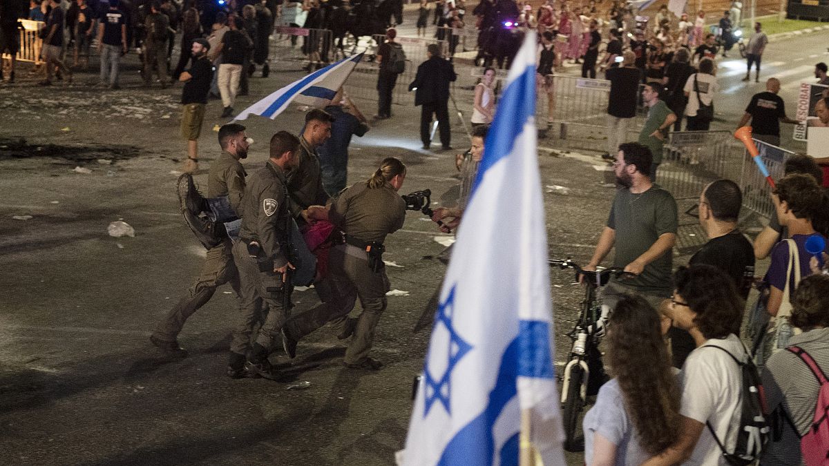 Israeli police remove a person protesting against Prime Minister Benjamin Netanyahu