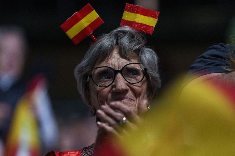 Une sympathisante avec un drapeau espagnol sur la tête participe au rassemblement du parti d'extrême droite espagnol Vox. "Europe Viva 24" à Madrid, mai 2024