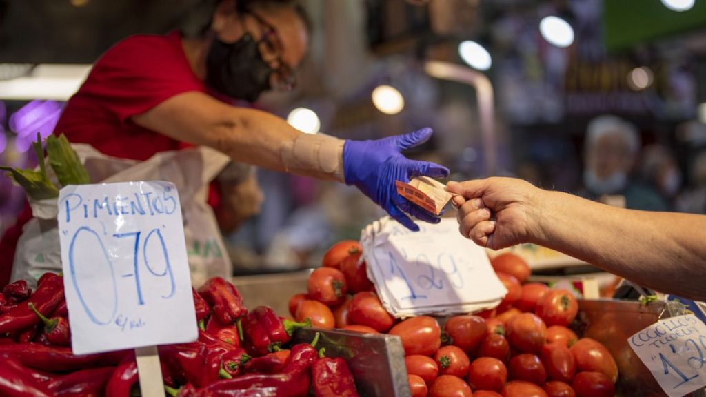 A customer pays for vegetables at the Maravillas market in Madrid, on May 12, 2022.