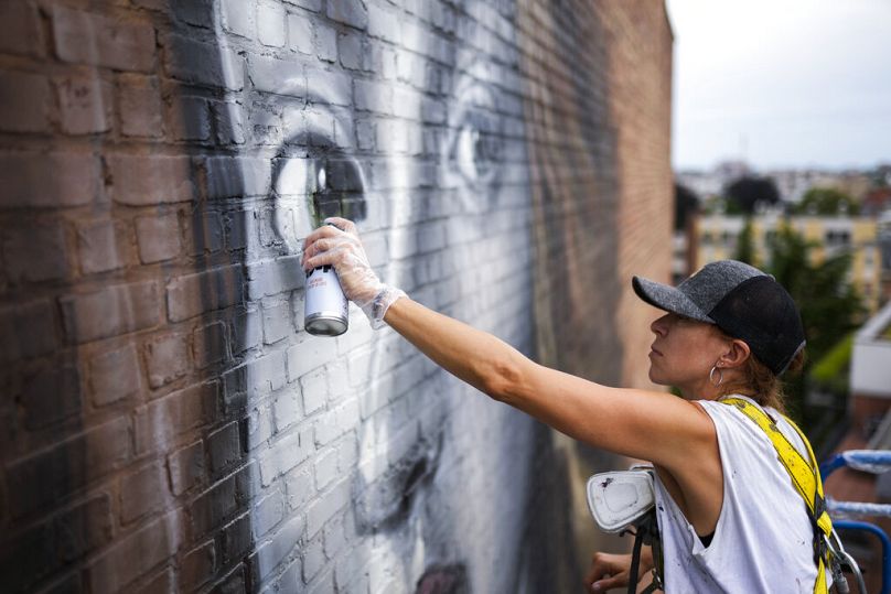 L'artiste de rue espagnole Lula Goce travaille sur une fresque géante à Bruxelles, juillet 2021