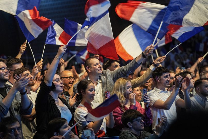 Des partisans du Rassemblement national d'extrême droite brandissent des drapeaux lors d'un meeting pour les prochaines élections européennes à Hénin-Beaumont, le 24 mai 2024.