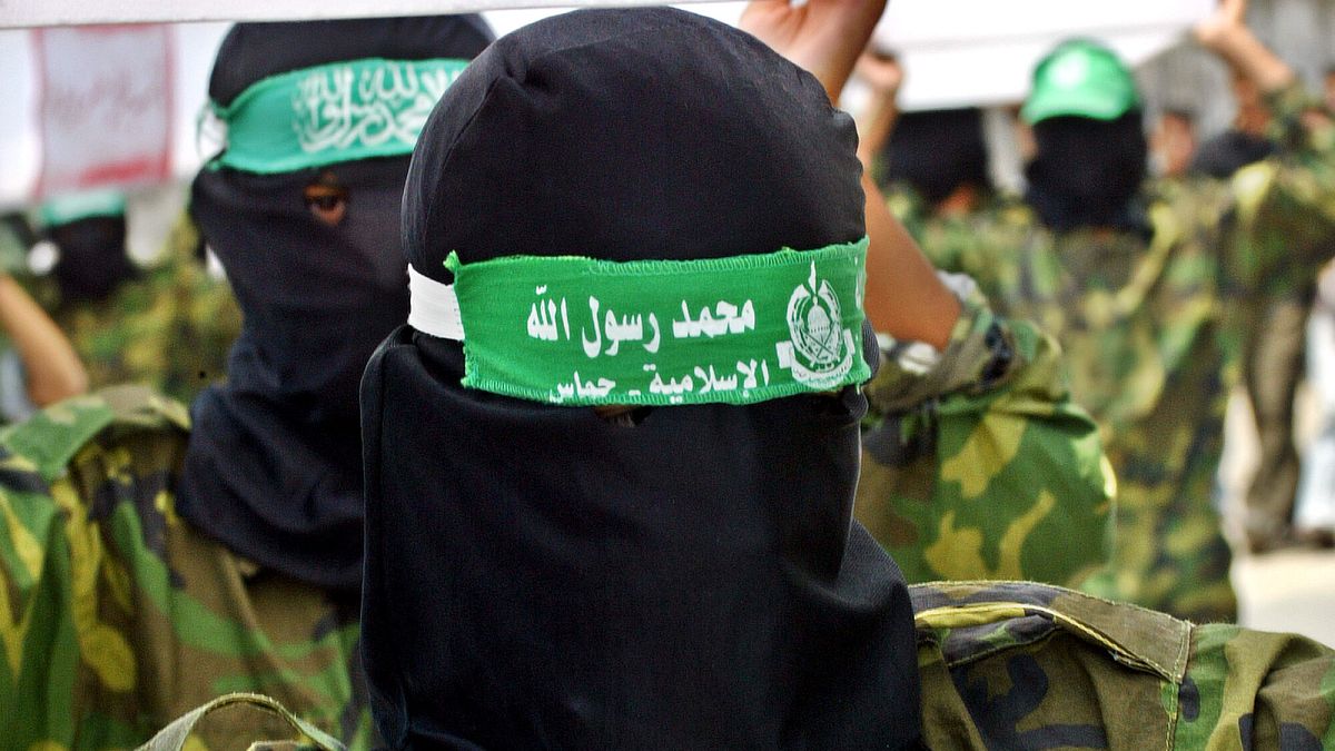 Masked Hamas militants in Gaza carry mock coffins of Palestinians who were killed during Israeli military operations.