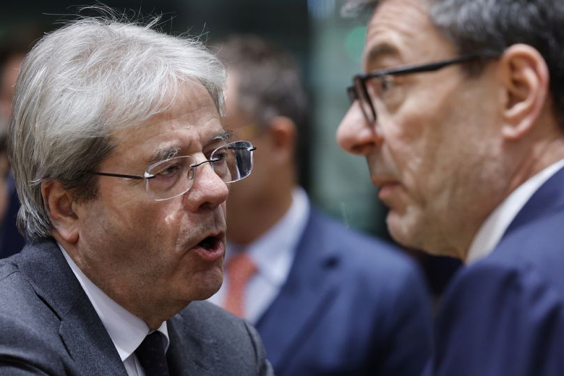 Le commissaire européen à l'économie Paolo Gentiloni s'entretient avec le ministre italien des Finances Giancarlo Giorgetti lors d'une réunion des ministres des Finances à Bruxelles, le 15 janvier 2024.