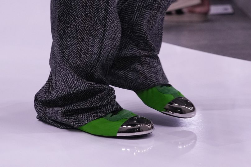 Le mannequin porte des chaussures vertes éblouissantes de la collection Prada Printemps-Été 2025.