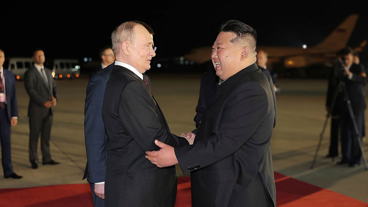 Russian President Vladimir Putin, center left, is greeted by North Korea