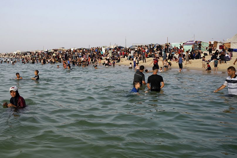 Des Palestiniens déplacés se rafraîchissent pendant une canicule sur la plage de Khan Younis, dans le sud de la bande de Gaza, le 20 mai 2024.