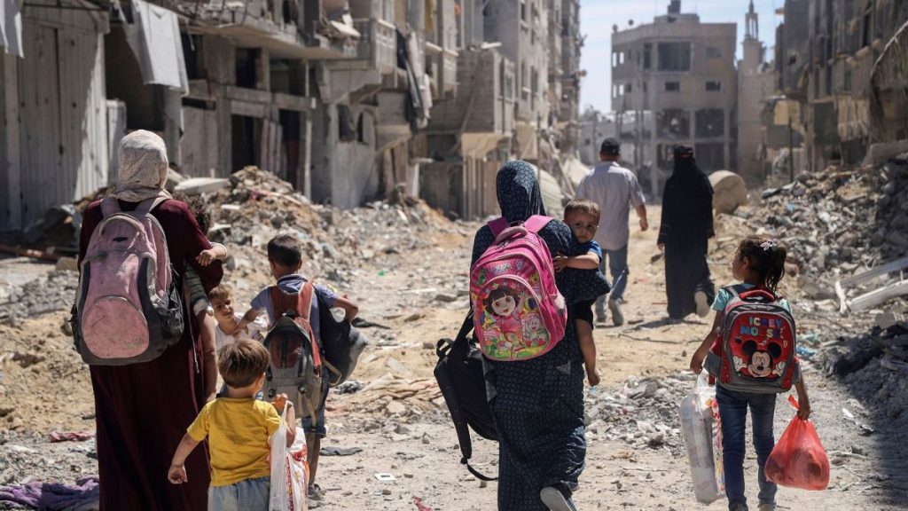 Palestinian women and their children walk though destruction in the wake of an Israeli air and ground offensive in Jebaliya, northern Gaza Strip, 31 May, 2024.