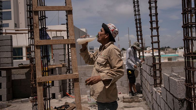 Jorge Moreno, un ouvrier, boit de l'eau aromatisée pour faire face à la canicule pendant sa journée de travail sur un chantier de construction à Veracruz, au Mexique, le 17 juin 2024. 