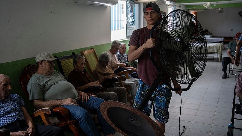 Le travailleur humanitaire Roger Duvan Lagunes transporte un éventail dans le Cogra, un refuge pour personnes âgées, à Veracruz, au Mexique, le 16 juin 2024.