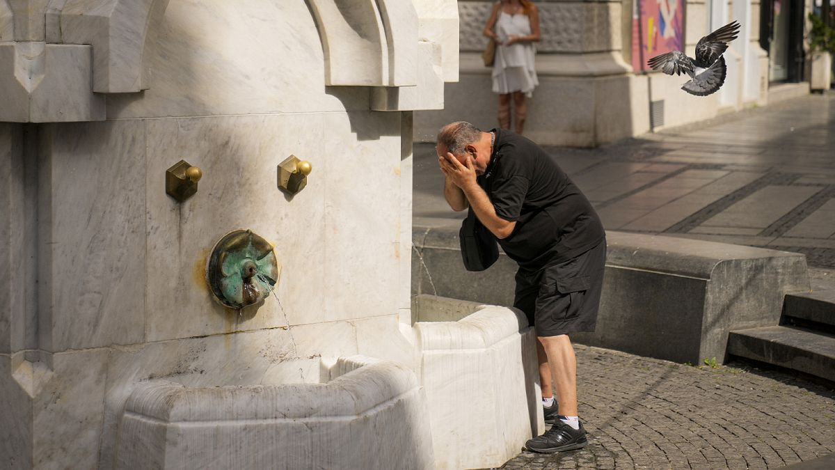 A man cools himself at a public fountain in Belgrade, 21 June 2024