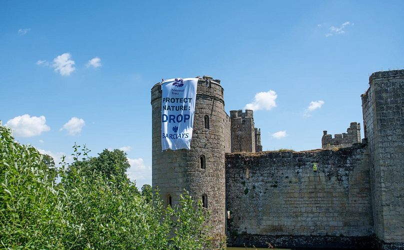 Fossil Free London déploie une bannière au château de Bodiam, monument classé Grade I, dans le Sussex, en Angleterre, pour protester contre les liens du propriétaire du National Trust avec Barclays.