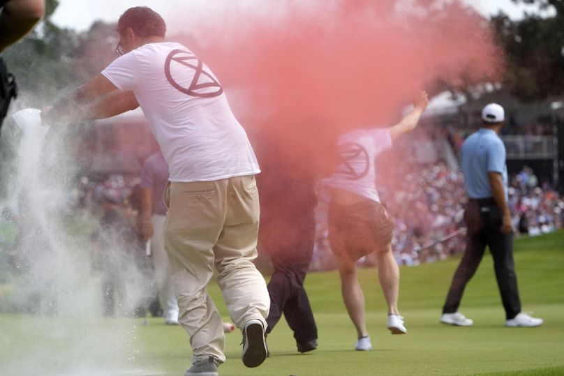 Les manifestants d'Extinction Rebellion courent sur le 18e green du PGA Travelers Championship dans le Connecticut, aux États-Unis.