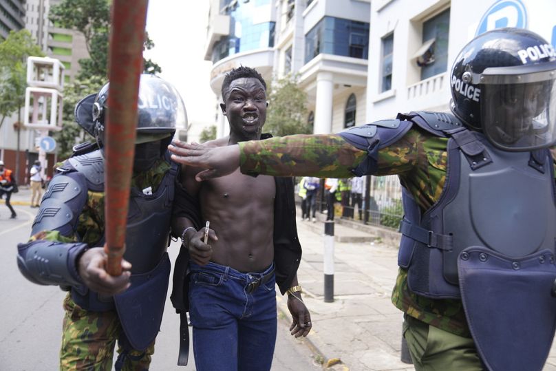 La police anti-émeute kenyane arrête mardi un homme lors d'une manifestation contre les hausses d'impôts proposées dans un projet de loi de finances à Nairobi.