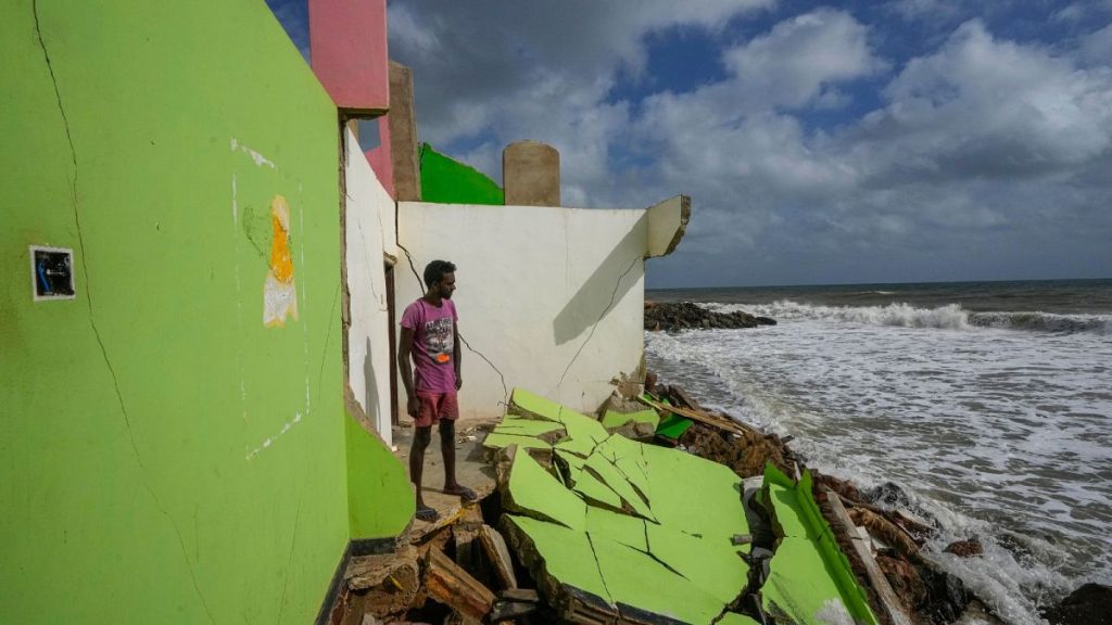 A man stands by the remains of his family