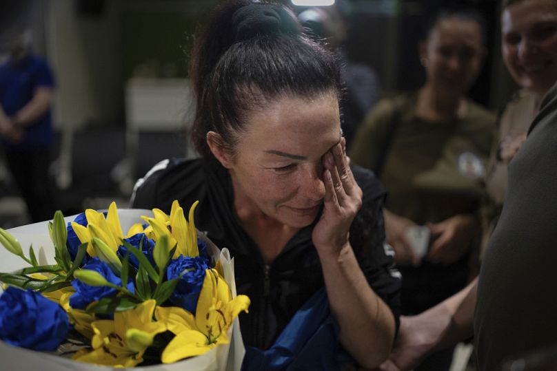 Olena Pekh, chercheuse au musée d'art de Horlivka, pleure alors qu'elle parle à sa fille via un signal vidéo à l'aéroport de Kiev, en Ukraine, le samedi 29 juin 2024.