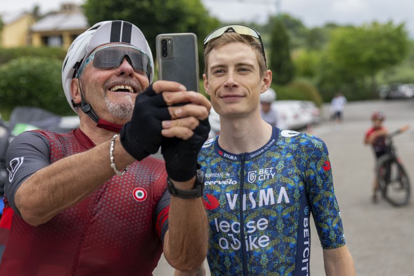 Un fan de cyclisme heureux prend un selfie avec Jonas Vingegaard du Danemark à Florence, Italie, le 23 juin 2024