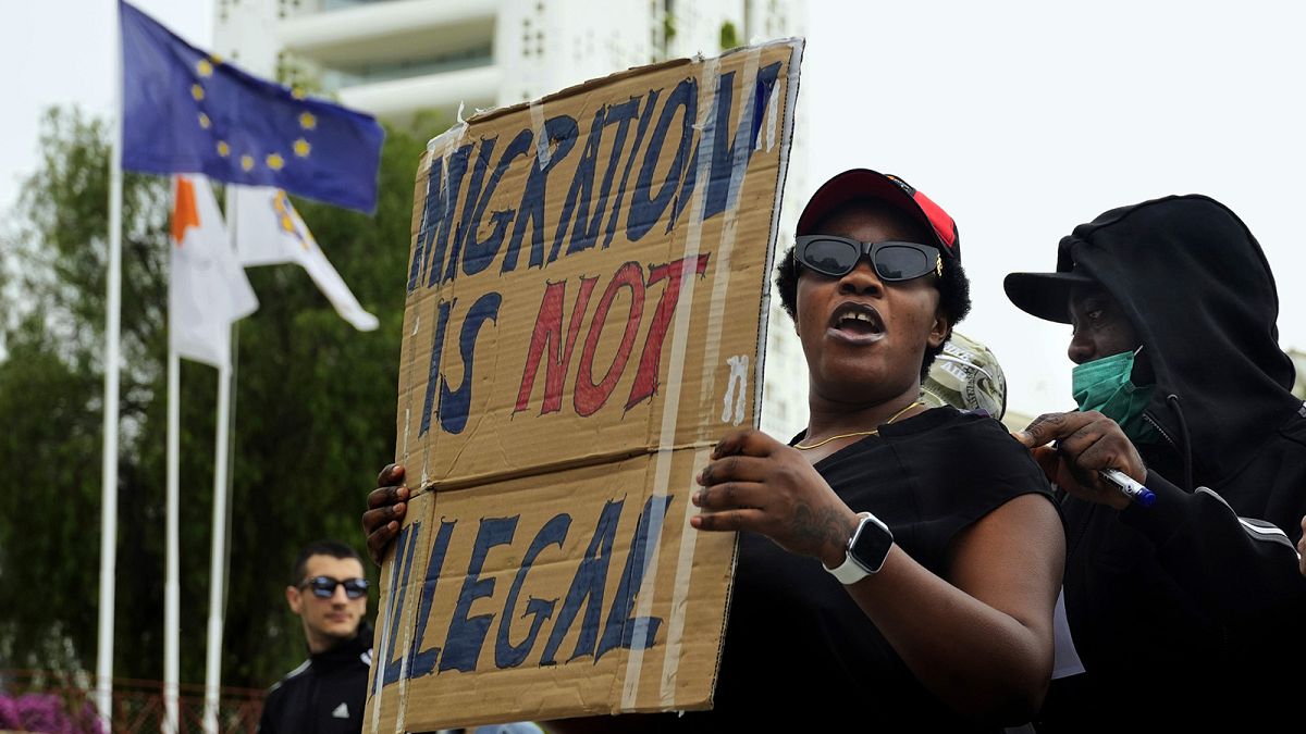 A person holds a placard during a protest against new government policies on migration, at Elephteria square in Nicosia, 20 April 2024