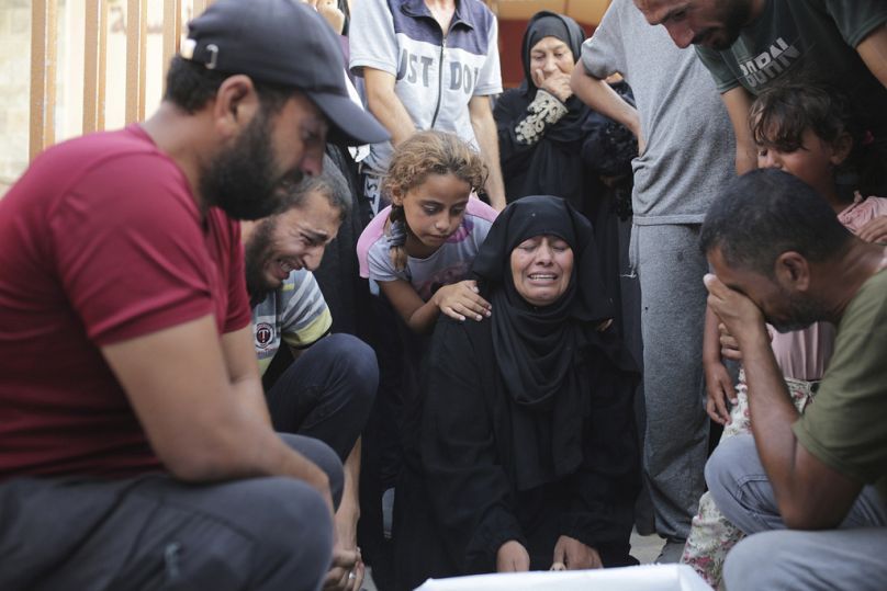 Une famille palestinienne pleure un être cher tué par les bombardements israéliens, alors qu'elle jette un dernier regard avant ses funérailles à Khan Younis, dans le sud de la bande de Gaza, le vendredi 21 juin.