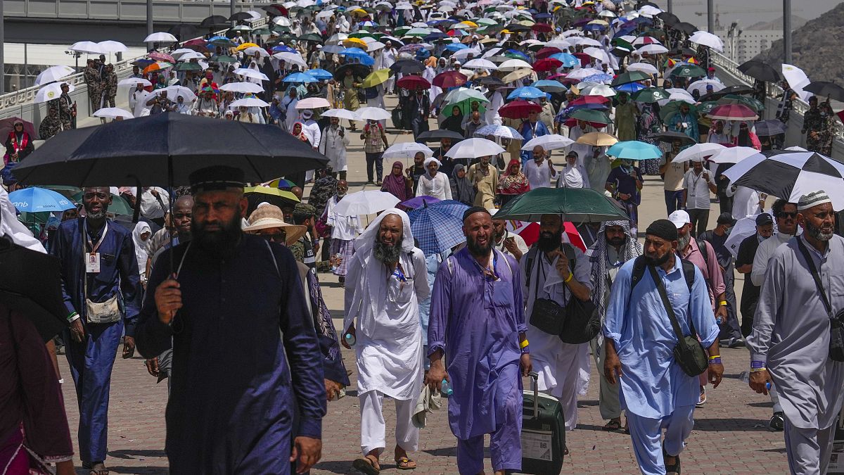Muslim pilgrims use umbrellas to shield themselves from the sun
