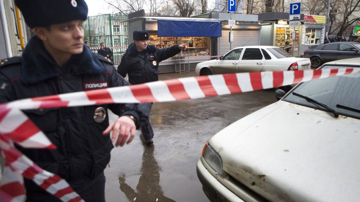 Police set a crime scene tape near a suspicious car, background, in Moscow, Russia, Saturday, Feb. 28, 2015.