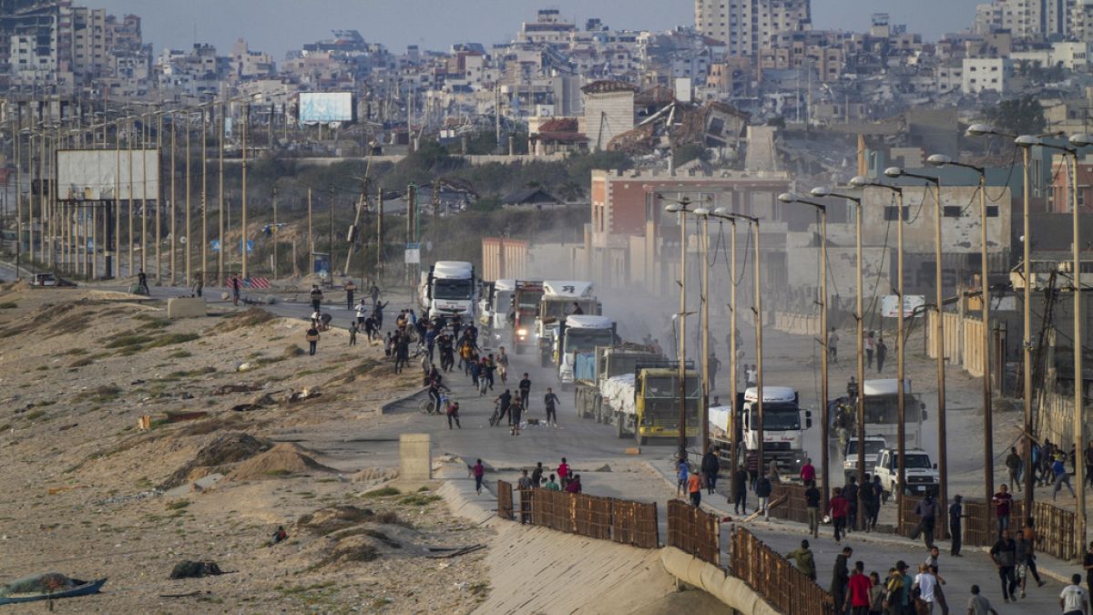 Palestinians storm rucks loaded with humanitarian aid brought in through a new U.S.-built pier, in the central Gaza Strip, Saturday, May 18, 2024.