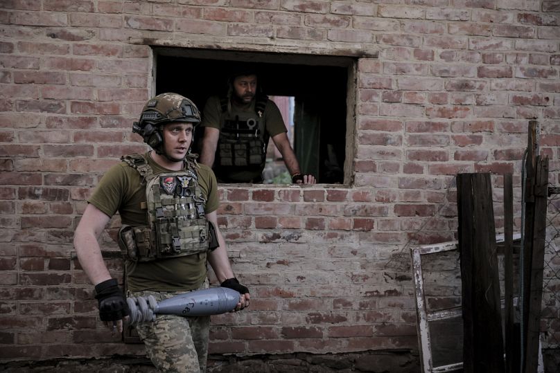 Des soldats ukrainiens se préparent à tirer un mortier de 120 mm vers une position russe sur la ligne de front dans un lieu tenu secret dans la région de Donetsk, juin 2024.