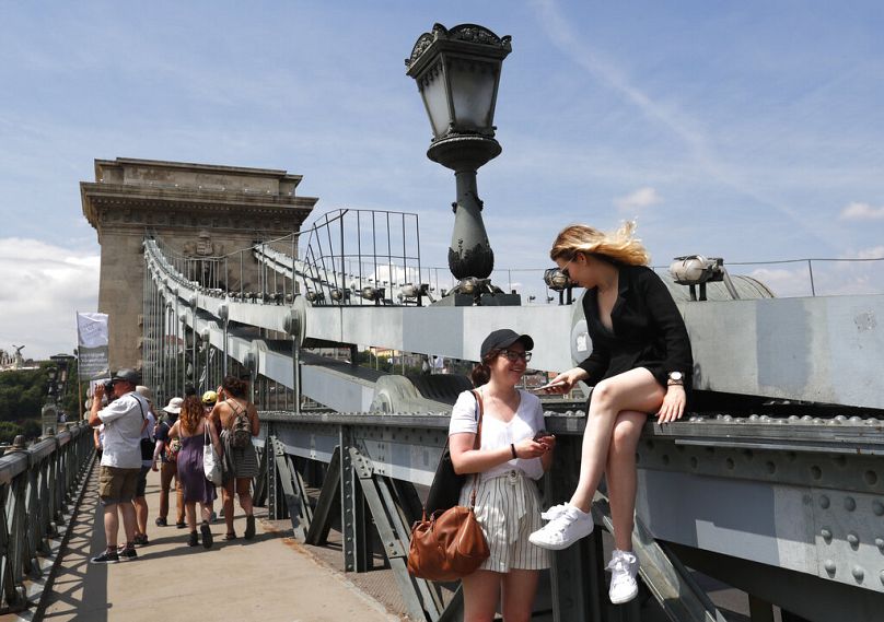 Des touristes et des Hongrois marchent sur le Pont des Chaînes sur le Danube à Budapest, juin 2019