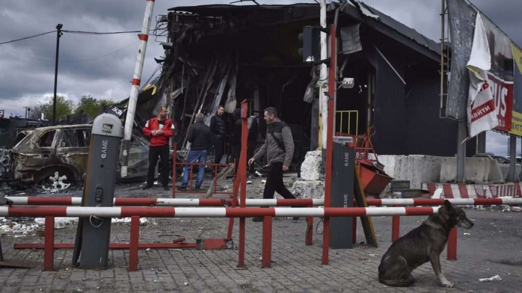 People stand at the scene of buildings damaged by Russian attack in Dnipro, Ukraine, Friday, April 19, 2024.