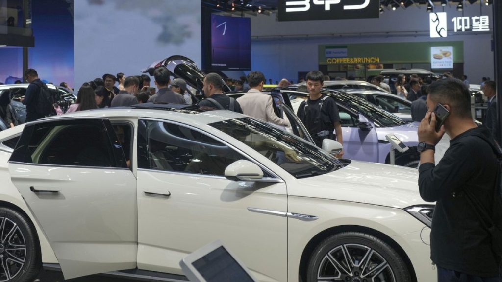 Visitors look at cars at the BYD booth during the China Auto Show in Beijing, China, Friday, April 26, 2024.