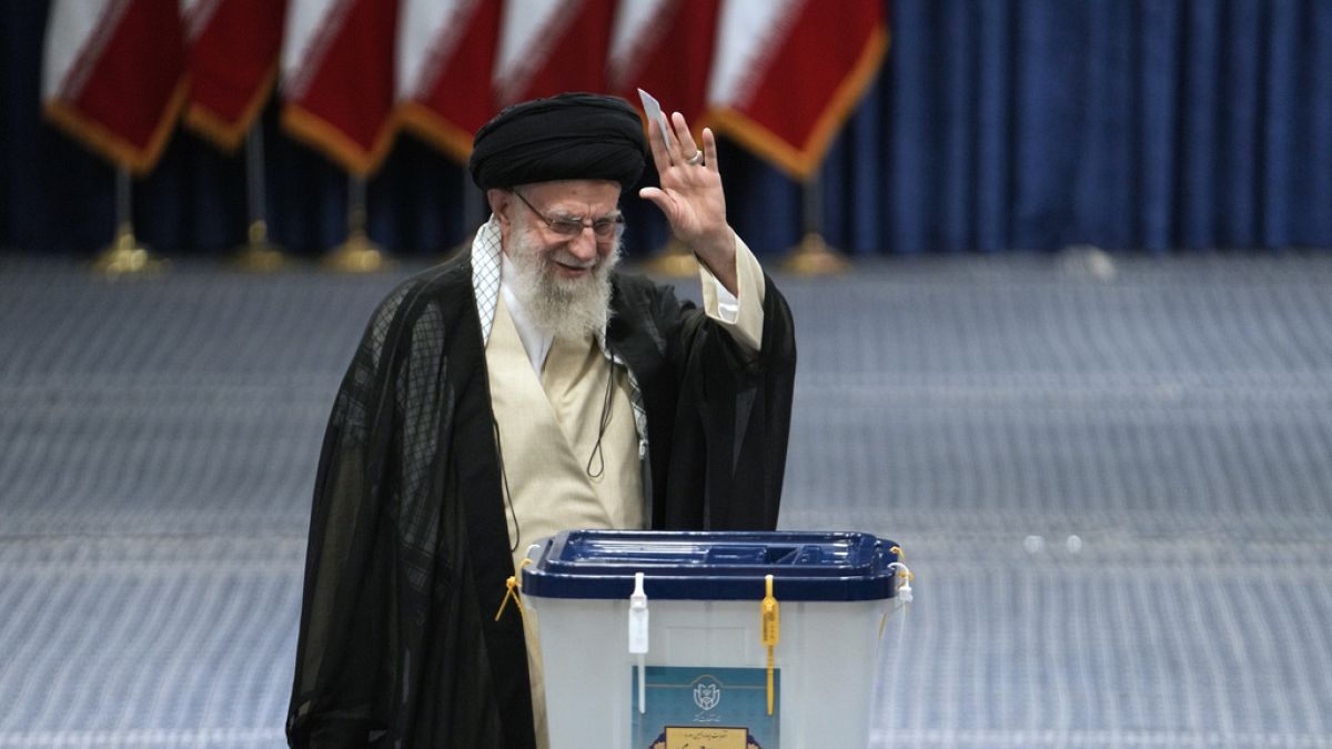 Iranian Supreme Leader Ayatollah Ali Khamenei waves to media before casting his ballot in the presidential election in Tehran, Iran, Friday, June 28, 2024.