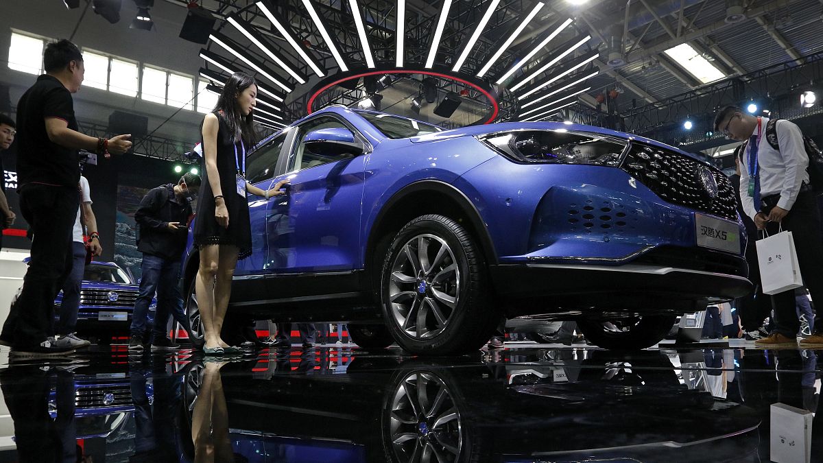 Journalists and visitors look at a Chinese car brand Hanteng X5 EV SUV on display at the China Auto China in Beijing, Thursday, April 26, 2018.