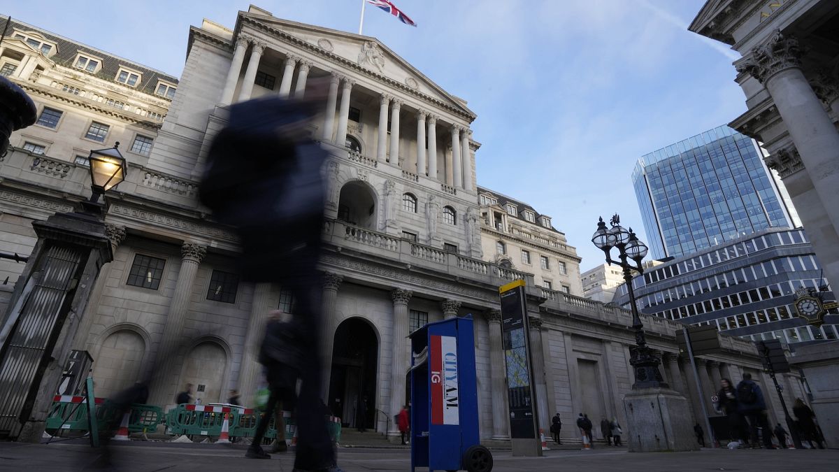 People walk past the Bank of England in London