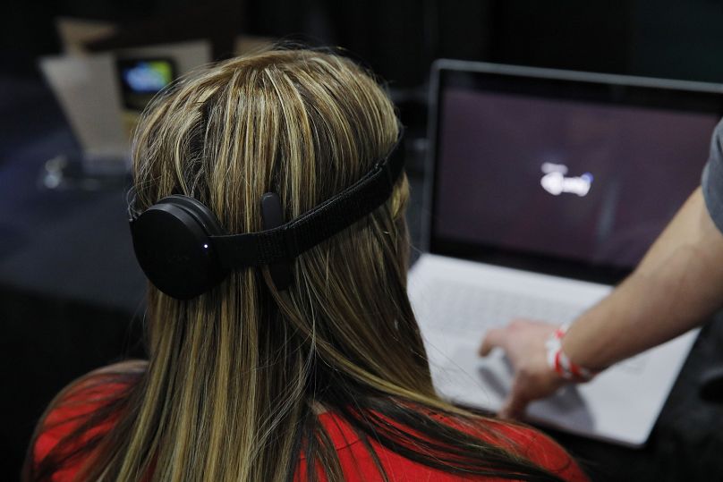 Une femme utilise le dispositif d'interface mains libres cerveau-ordinateur NextMind sur le stand NextMind lors du CES Unveiled.  2020